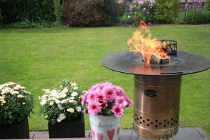 Holz nachlegen in die Feuertonne mit Feuerplatte