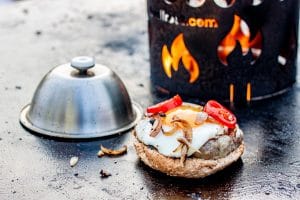 Hamburger auf der Feuerplatte mit Burgerglocke