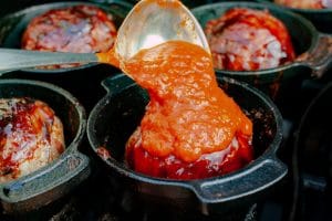 Die Bacon Bomb wird mit Tomatensauce übergossen