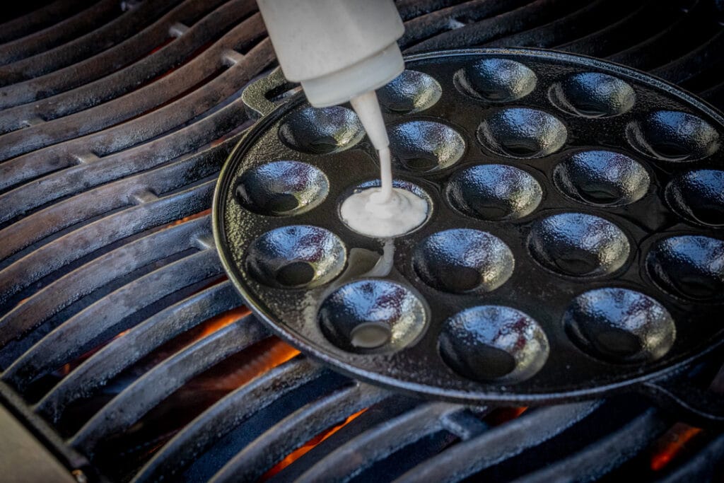 Poffertjes-Teig in die Pfanne füllen