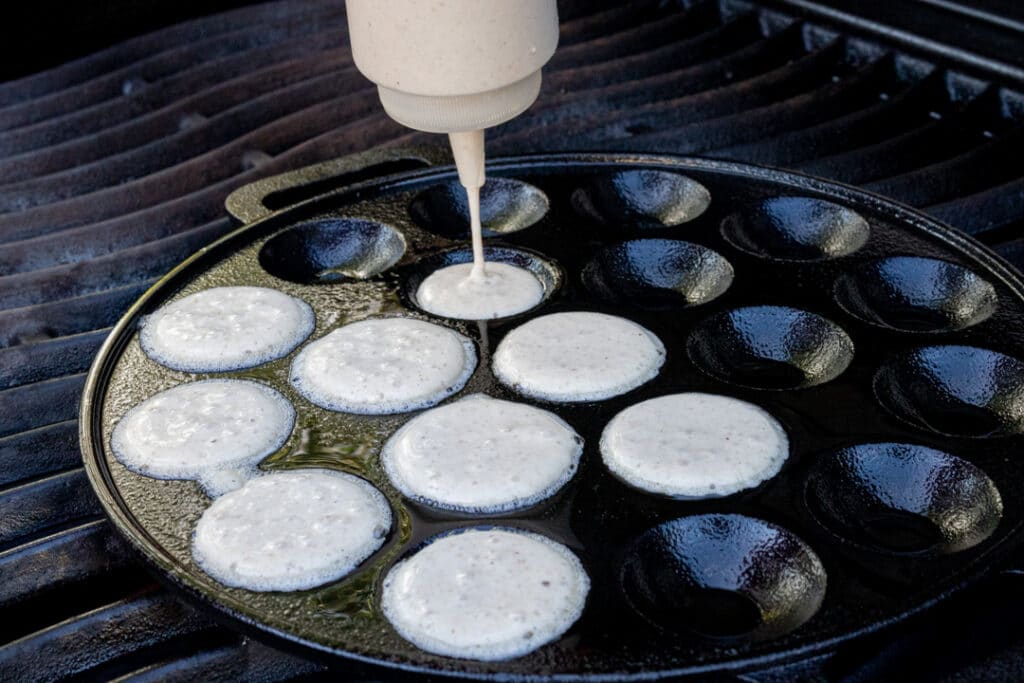 Poffertjes-Teig in die Pfanne füllen