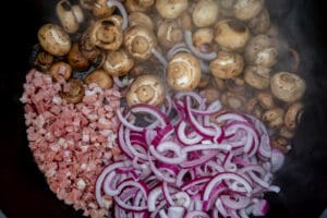 Champignons, Zwieben und Speck anbraten